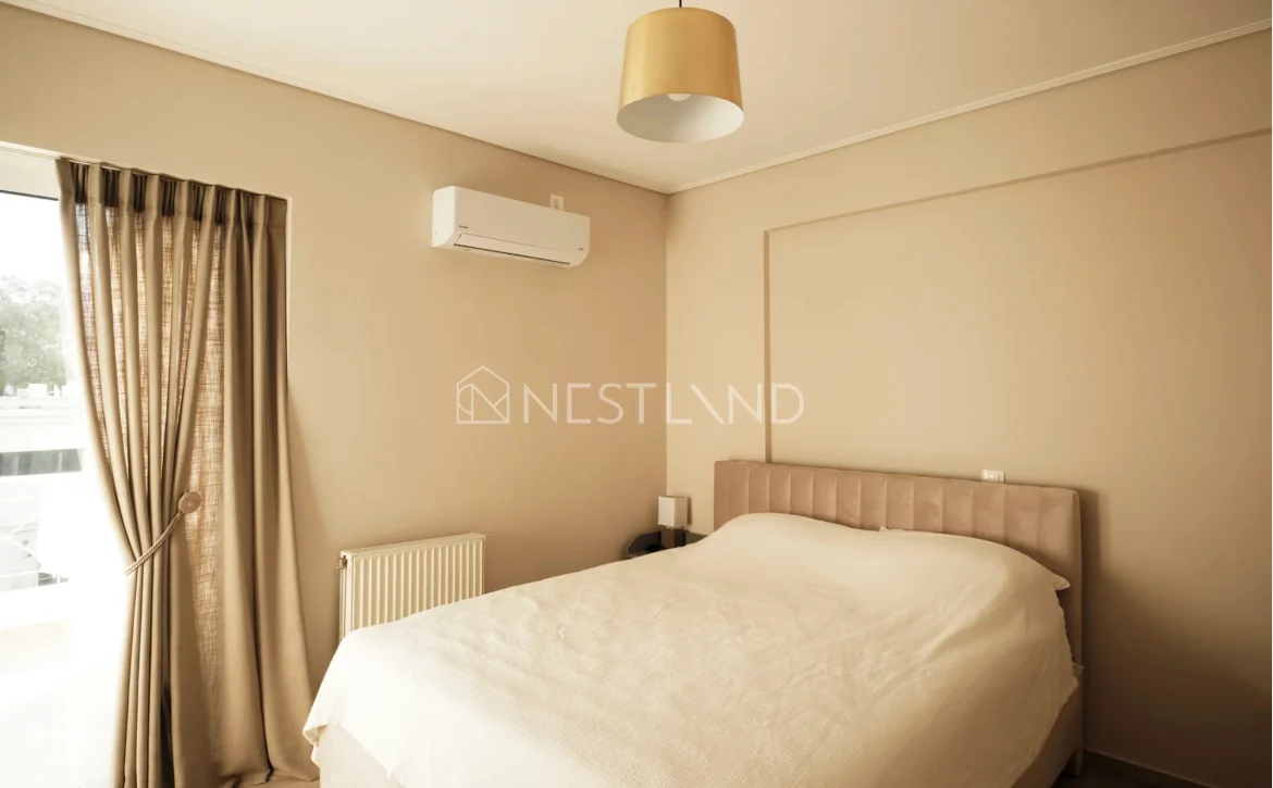 Minimalist bedroom with a beige theme, a large bed, pendant light, and an air conditioner.