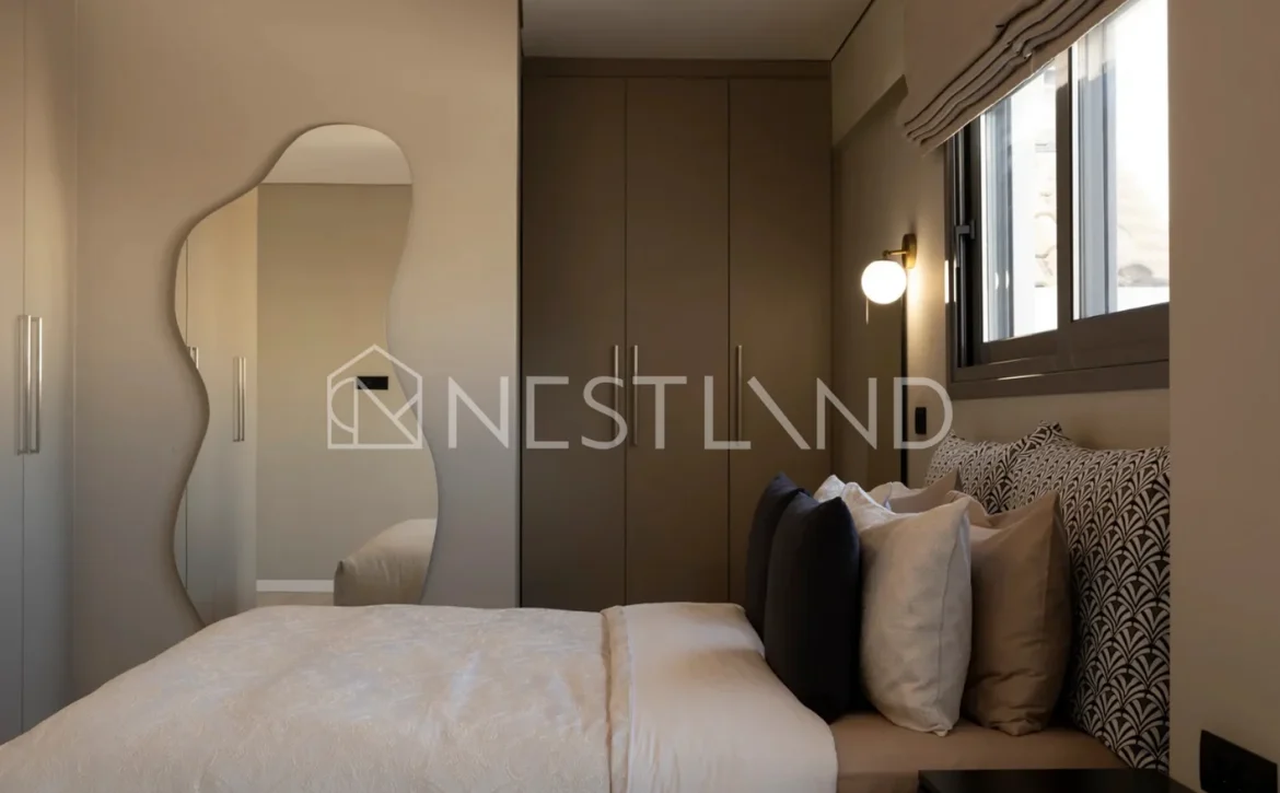 Modern bedroom with a large bed, mirror, and tasteful lighting.