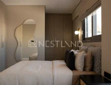 Modern bedroom with a large bed, mirror, and tasteful lighting.
