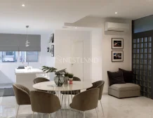 Modern kitchen and dining area with sleek design, marble flooring, and neutral tones.