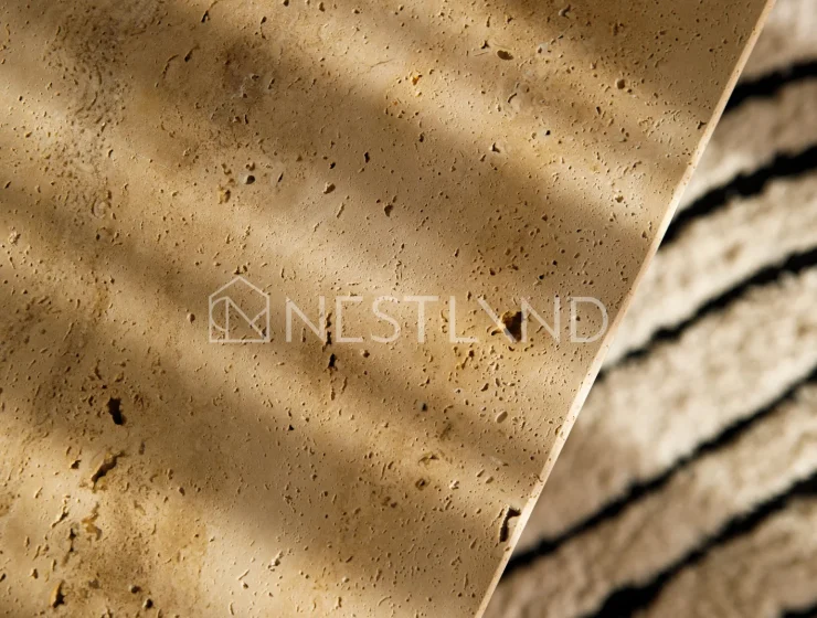 Close-up of wooden coffee table on a rug, in soft lighting.
