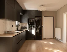 Modern kitchen interior with dark cabinetry, marble backsplash, and stainless steel appliances.