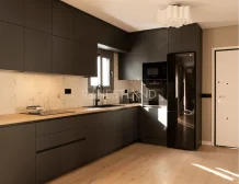 Modern kitchen with dark cabinets, marble backsplash, and sunlight streaming onto a wooden floor.