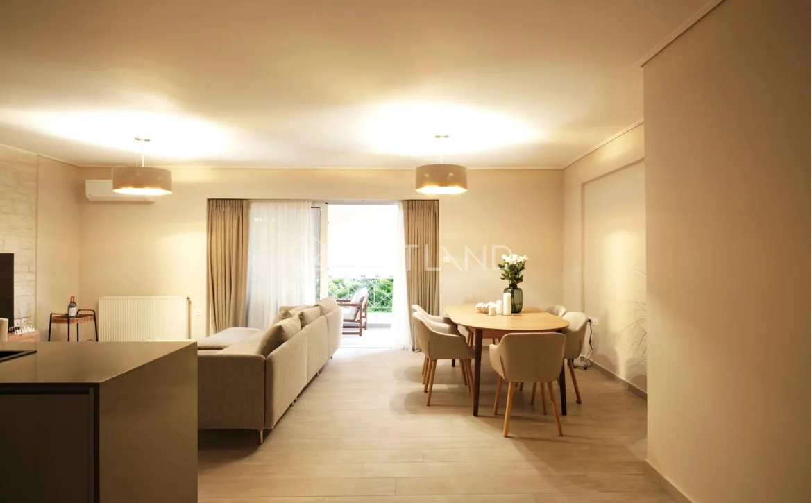 Modern living and dining area with beige tones, sofa, table, and open balcony door.