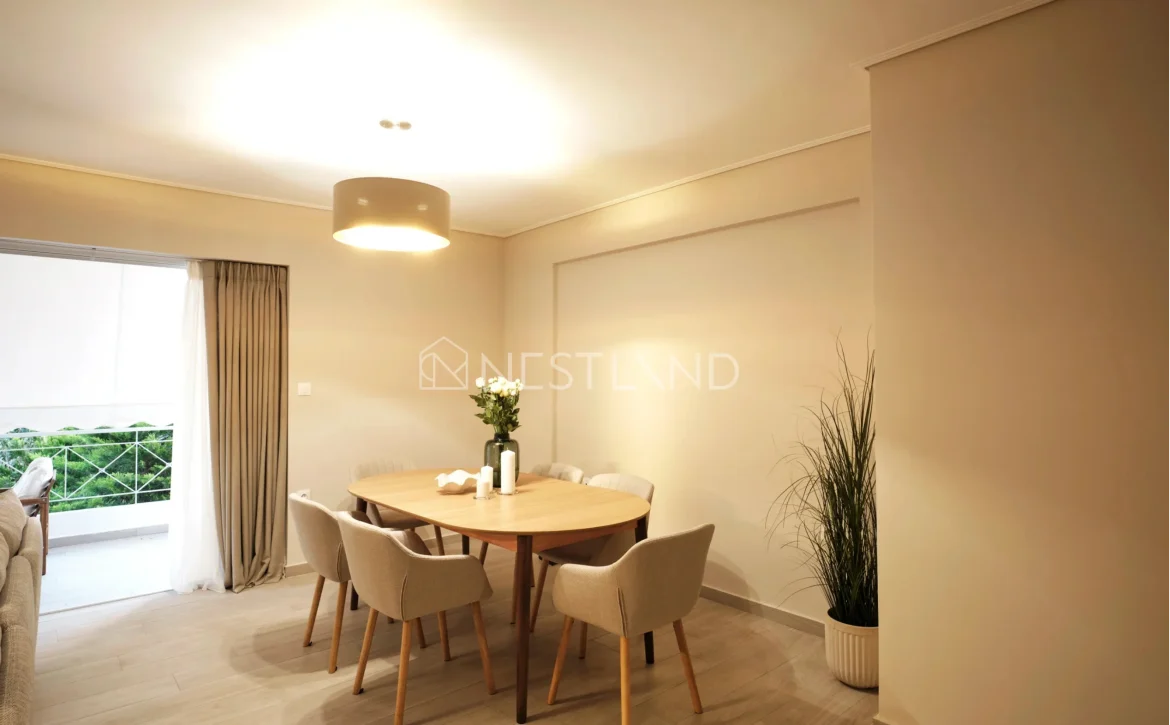 Modern dining room with wooden table, beige chairs, pendant light, and large window.