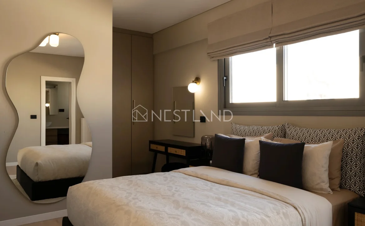 Elegant bedroom with a large bed, unique mirror, window, and stylish decor.