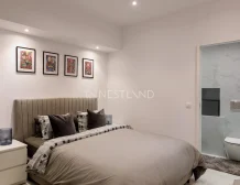 Modern bedroom with a bed, artwork on the wall, and an en suite bathroom.