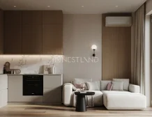 Modern living room with kitchenette, sofa, and large window overlooking trees.