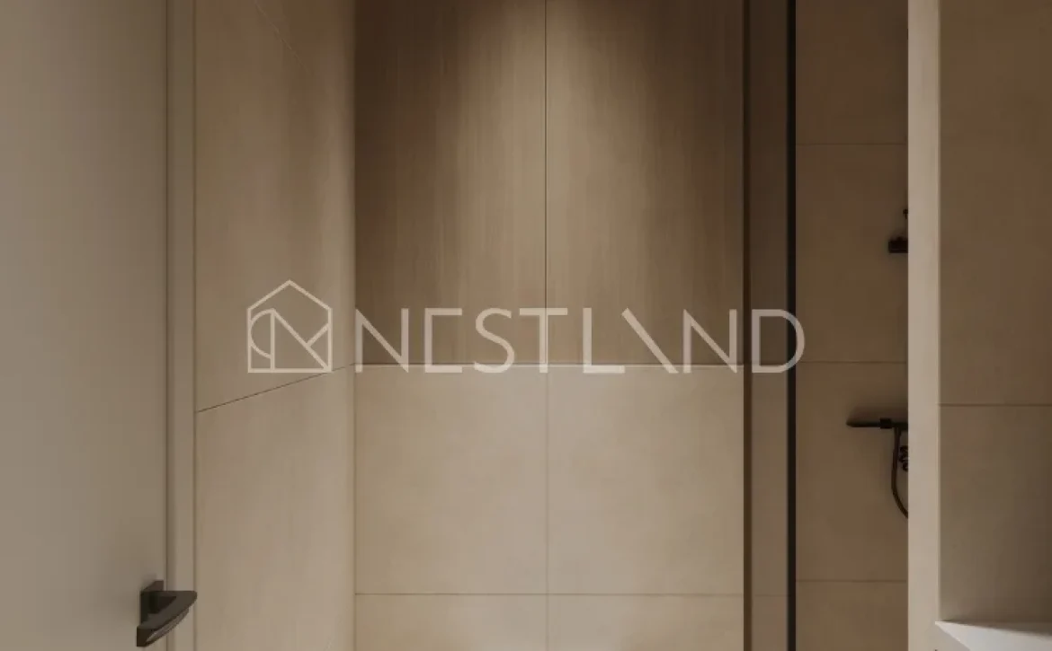 Modern bathroom with a wall-mounted toilet and a washing machine, featuring neutral tones and a glass partition.