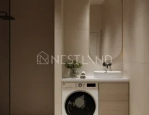 Modern bathroom with integrated laundry area featuring a washing machine and a stylish basin under a mirror.