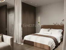 Modern bedroom with a beige upholstered bed, white bedding, brown accents, and minimalist decor.