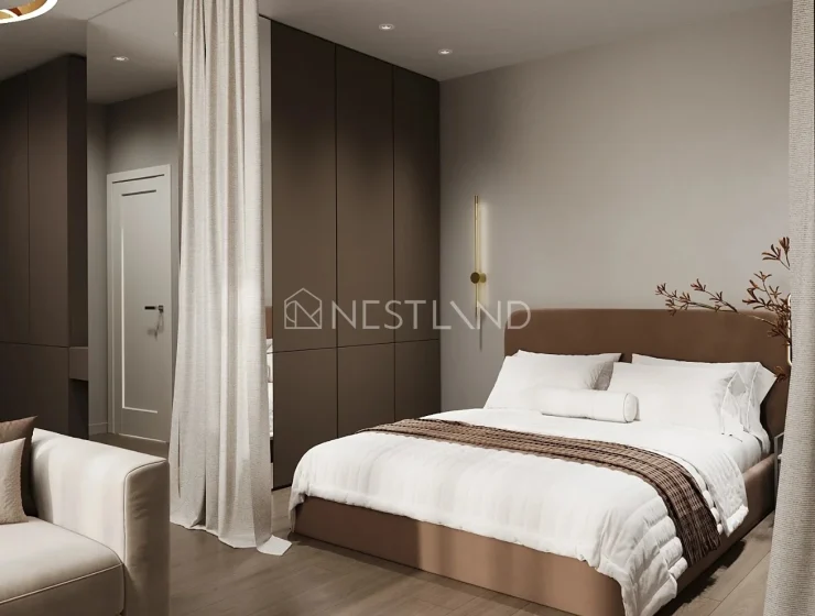 Modern bedroom with a beige upholstered bed, white bedding, brown accents, and minimalist decor.