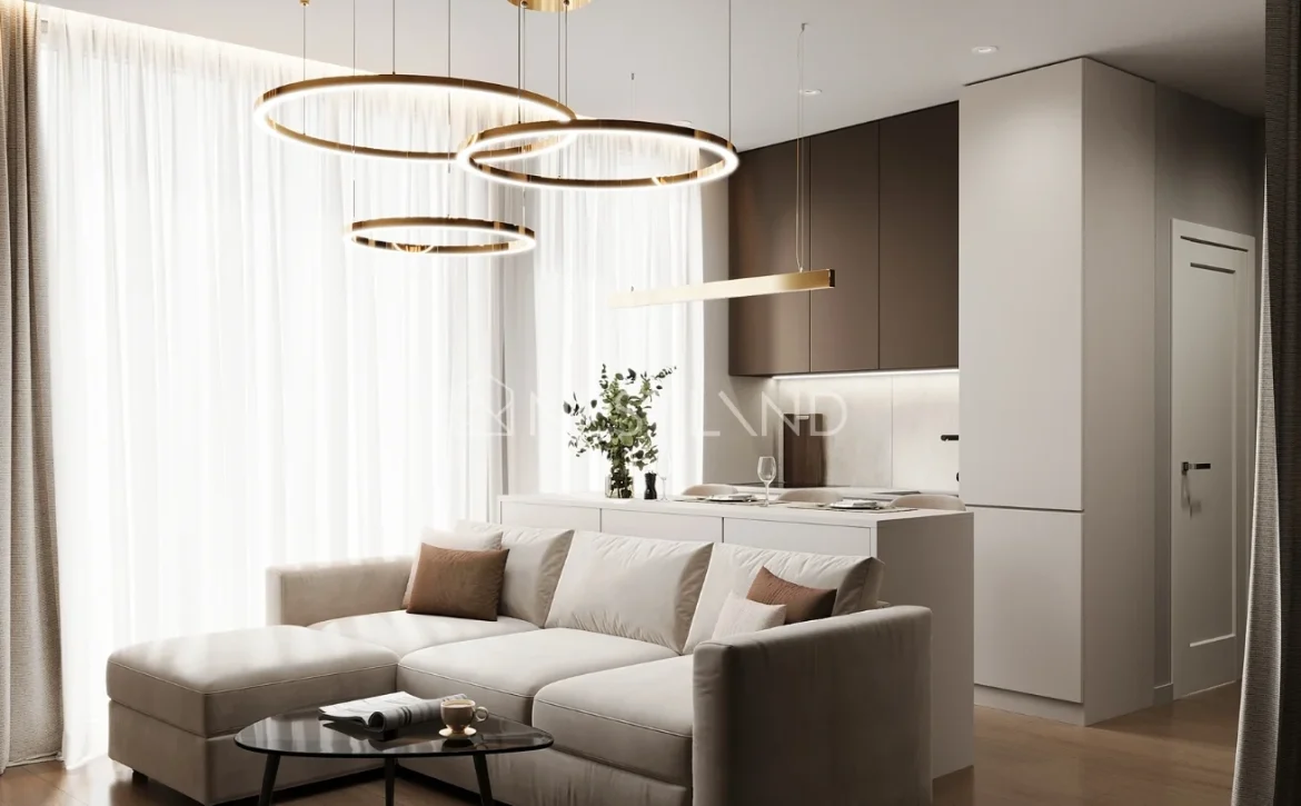 Modern living room with beige sofa, circular hanging lights, and a kitchen in the background.
