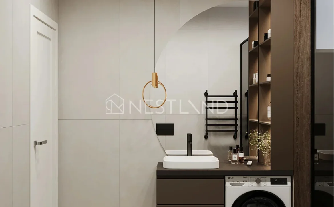 Modern bathroom interior with a pendant light, vanity, towel ladder, and washing machine.