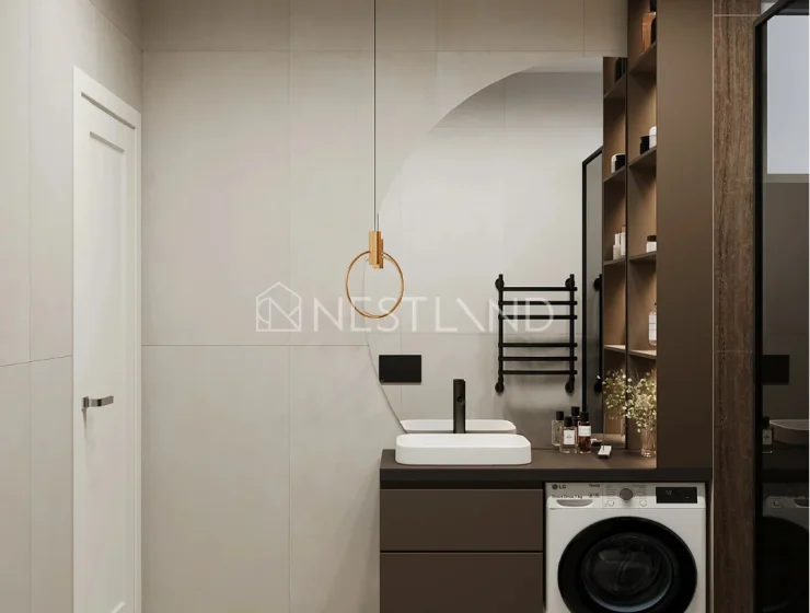 Modern bathroom interior with a pendant light, vanity, towel ladder, and washing machine.