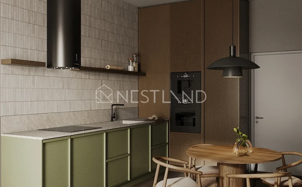 Modern kitchen with green cabinets, gray countertops, black appliances, and a round wooden dining table with four chairs.
